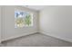 Bedroom with neutral carpet and walls, and a window overlooking trees at 905 Moye Dr, Raleigh, NC 27606