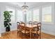 Inviting dining room featuring hardwood floors, plantation shutters, and an elegant chandelier, perfect for gatherings at 905 Moye Dr, Raleigh, NC 27606