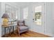 Cozy entryway with wood floors, gray chair, decorative mirror, and view to the outside at 905 Moye Dr, Raleigh, NC 27606