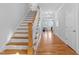 Bright foyer with wood floors, staircase, and a glimpse into the living room at 905 Moye Dr, Raleigh, NC 27606