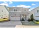 Charming two-story home with a well-manicured front yard, attached garage, and inviting front porch at 905 Moye Dr, Raleigh, NC 27606
