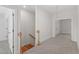 Hallway with carpet, hardwood stairs, and a view of the room with a white door at 905 Moye Dr, Raleigh, NC 27606