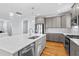 An open concept kitchen featuring grey cabinets, stainless steel appliances and a large island with white countertop at 905 Moye Dr, Raleigh, NC 27606