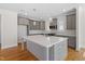 Well-lit kitchen featuring gray cabinets, hardwood floors, and a large center island with a sink at 905 Moye Dr, Raleigh, NC 27606