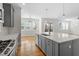 Open kitchen with grey cabinets, hardwood floors, a center island, and stainless steel appliances at 905 Moye Dr, Raleigh, NC 27606