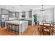 Modern kitchen featuring gray cabinets, stainless appliances, a large island with seating, and a dining area with a plant at 905 Moye Dr, Raleigh, NC 27606