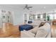 Open-concept living room with hardwood floors, a ceiling fan, and comfortable seating next to a modern kitchen at 905 Moye Dr, Raleigh, NC 27606