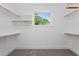 Walk-in closet with custom shelving and a bright window overlooking a lush landscape at 905 Moye Dr, Raleigh, NC 27606