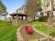 Charming backyard featuring a stone gazebo, manicured flower beds, and a well-maintained lawn at 9220 Meadow Mist Ct, Raleigh, NC 27617