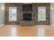 Basement showcases a stone fireplace and two large windows filling the room with natural light at 9220 Meadow Mist Ct, Raleigh, NC 27617