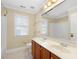 Bathroom with double sink vanity, toilet, window, and bathtub at 9220 Meadow Mist Ct, Raleigh, NC 27617