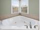 Close-up of the corner bathtub and faucets in the Primary bathroom at 9220 Meadow Mist Ct, Raleigh, NC 27617