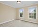 Bright bedroom with carpet, two windows, and base molding throughout the space at 9220 Meadow Mist Ct, Raleigh, NC 27617