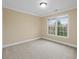 Neutral bedroom featuring carpet, a window, and base molding at 9220 Meadow Mist Ct, Raleigh, NC 27617