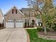 Charming two-story brick home with a well-maintained lawn, two-car garage, and attractive landscaping at 9220 Meadow Mist Ct, Raleigh, NC 27617
