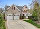 Beautiful two-story brick home featuring a well-manicured lawn, attached two-car garage, and red shutters at 9220 Meadow Mist Ct, Raleigh, NC 27617