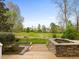 Stylish stone fire pit with landscaping and views of golf course at 9220 Meadow Mist Ct, Raleigh, NC 27617