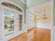 Foyer with hardwood floors, entry doors, and view into dining room with elegant chandelier at 9220 Meadow Mist Ct, Raleigh, NC 27617