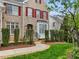 Elegant brick home featuring a decorative front entrance with arched doorway and manicured landscaping at 9220 Meadow Mist Ct, Raleigh, NC 27617