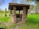 An outdoor stone gazebo nestled in a lush green yard, ideal for relaxation and outdoor gatherings at 9220 Meadow Mist Ct, Raleigh, NC 27617