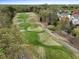 Picturesque aerial view of a golf course adjacent to a residential community, showcasing serene green landscapes at 9220 Meadow Mist Ct, Raleigh, NC 27617