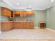 Functional kitchenette with wooden cabinets, neutral countertop, and tile floors at 9220 Meadow Mist Ct, Raleigh, NC 27617