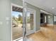 View of a living room with a stone fireplace through an open doorway to backyard at 9220 Meadow Mist Ct, Raleigh, NC 27617