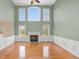 This grand living room features a fireplace, hardwood floors, and many bright windows at 9220 Meadow Mist Ct, Raleigh, NC 27617