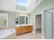 Bright bathroom boasts a skylight, a large tub, and a separate shower, combining luxury with functionality at 9220 Meadow Mist Ct, Raleigh, NC 27617