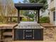 Close-up of outdoor kitchen featuring grill, countertop, and stone surround at 9220 Meadow Mist Ct, Raleigh, NC 27617