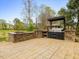 Outdoor kitchen featuring stone surround grill, countertop, and fire pit at 9220 Meadow Mist Ct, Raleigh, NC 27617
