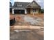 Exterior view of a charming single-story home with a two-car garage and unfinished front yard at 100 Slippery Elm Rd, Youngsville, NC 27596