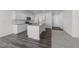 Bright kitchen featuring white cabinetry, a granite island, stainless steel appliances, and hardwood flooring at 103 Gladstone Loop, Clayton, NC 27520