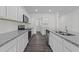 Well-lit kitchen featuring modern appliances, white cabinets, granite countertops, and dark wood-look flooring at 103 Gladstone Loop, Clayton, NC 27520