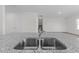 Detailed view of a kitchen sink with granite countertops, stainless steel fixtures, and a bright, open floor plan at 103 Gladstone Loop, Clayton, NC 27520