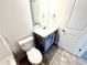 A small bathroom with a toilet, sink, mirror, and tile floor at 107 Southern Estates Dr, Sanford, NC 27330