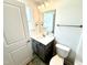 A bathroom with gray vanity, a mirror, toilet, and bright lighting at 107 Southern Estates Dr, Sanford, NC 27330