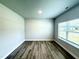 Bedroom with wood-look floors, a large window with blinds, and neutral paint at 107 Southern Estates Dr, Sanford, NC 27330