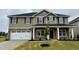 Charming two-story home with a stone facade and a two-car garage, complemented by a freshly landscaped yard at 107 Southern Estates Dr, Sanford, NC 27330