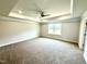 Spacious main bedroom featuring tray ceiling, carpet, and large windows at 107 Southern Estates Dr, Sanford, NC 27330