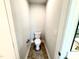 A bright powder room featuring a white toilet, neutral walls and wood-look floors at 107 Southern Estates Dr, Sanford, NC 27330