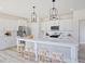 Stylish white kitchen features a large island with seating, stainless steel appliances, and modern lighting at 1107 Shovelhead Dr # Homesite 39, Durham, NC 27703