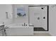 Bright bathroom showcasing a soaking tub, sleek glass shower with dark fixtures, and white subway tile at 1136 Remey Ave, Wake Forest, NC 27587