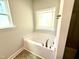 Soaking tub with decorative windows in a bright bathroom at 119 Southern Estates Dr, Sanford, NC 27330
