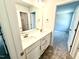 Bathroom featuring dual sinks, white cabinets, and a view to the bedroom at 119 Southern Estates Dr, Sanford, NC 27330