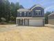 Two story home with blue siding, black shutters and a two car garage at 143 Mildred Place, Broadway, NC 27505
