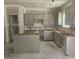Unfinished kitchen featuring gray cabinets and a kitchen island awaiting completion at 143 Mildred Place, Broadway, NC 27505