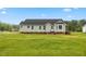 Back exterior view of a gray home and large yard at 16 Monarch Trl, Selma, NC 27576