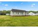 Rear exterior of the house with large lawn and view of neighboring homes at 16 Monarch Trl, Selma, NC 27576