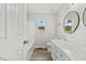Bright bathroom with double sink vanity, white fixtures, and wood-look floors at 16 Monarch Trl, Selma, NC 27576